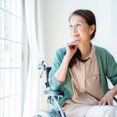 リビングから外を眺める車椅子の女性