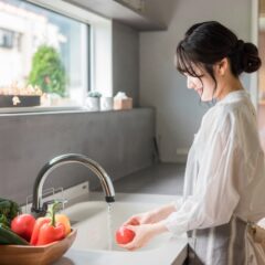キッチンで野菜を洗う女性