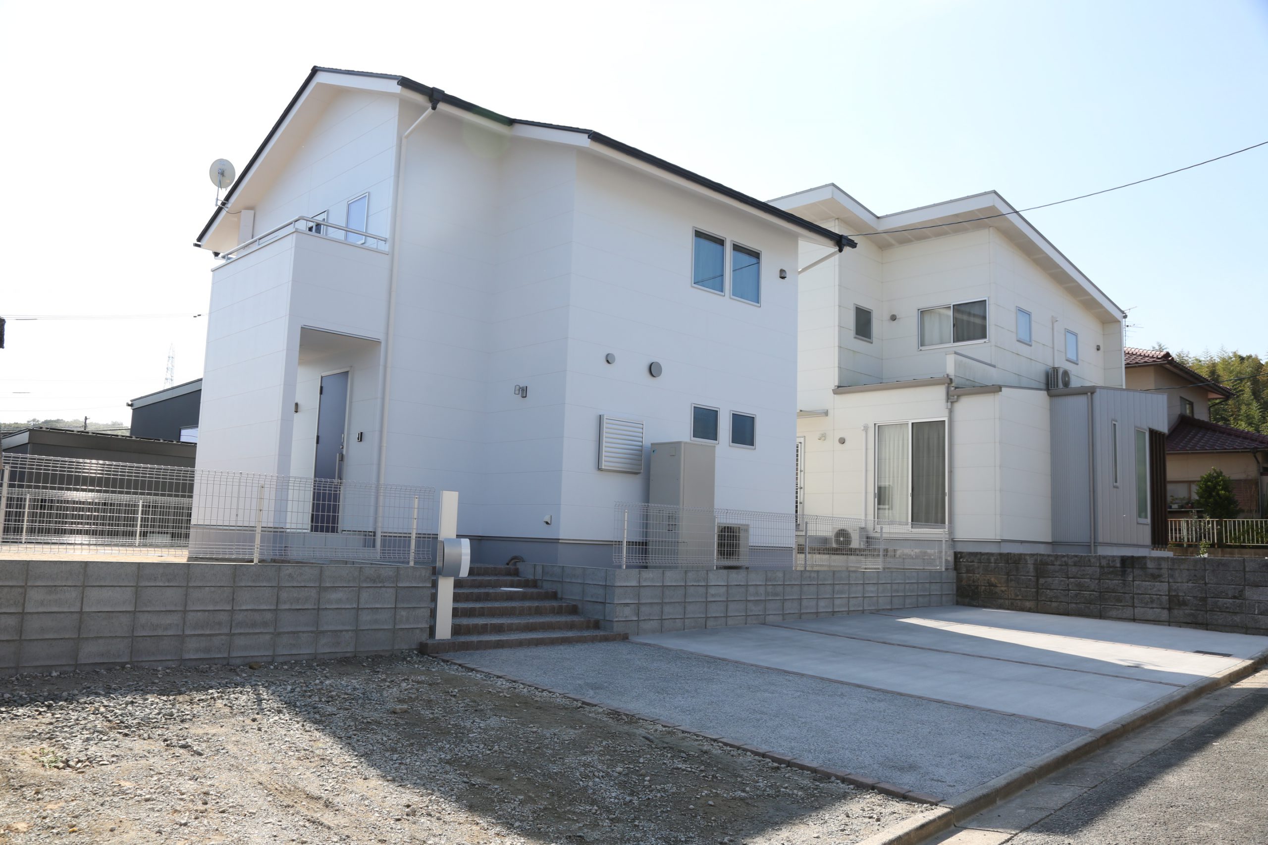 高台に建つ白い二階建てのお家