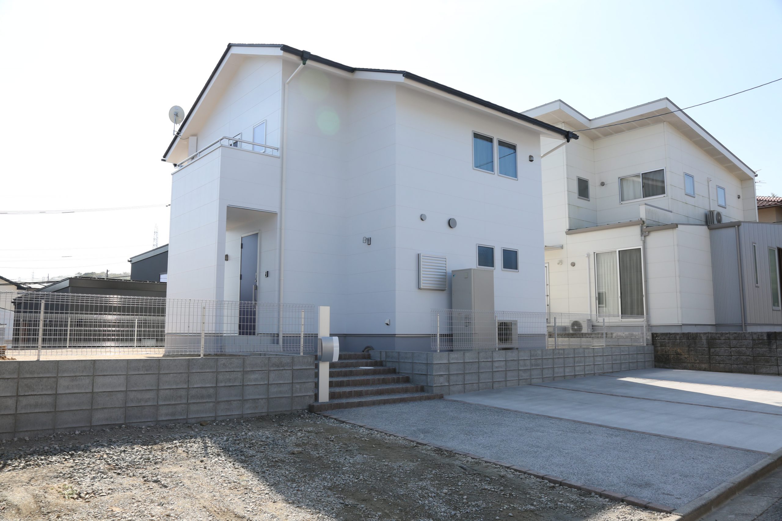 高台に建つ白い二階建てのお家