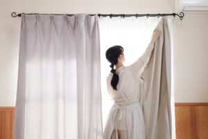 カーテンを取り付ける女性