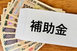 補助金と書かれた封筒とお金