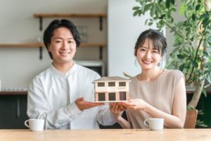 家の模型をもつ夫婦