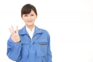 3と指でつくる作業服の女性