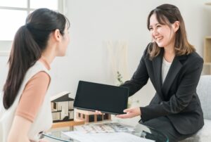 住宅メーカーの人と笑顔で話す女性