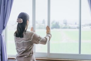 窓を開けて換気する女性