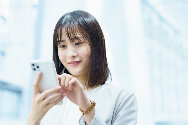 外出先でスマートフォンを操作する女性