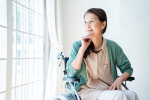リビングから外を眺める車椅子の女性