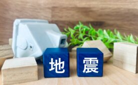 地震の文字と倒壊した家の模型