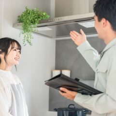 換気扇の説明をする作業着の男性と女性