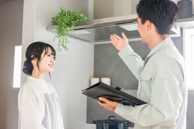 換気扇の説明をする作業着の男性と女性