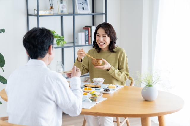 夫婦が笑いながら食卓を囲む様子